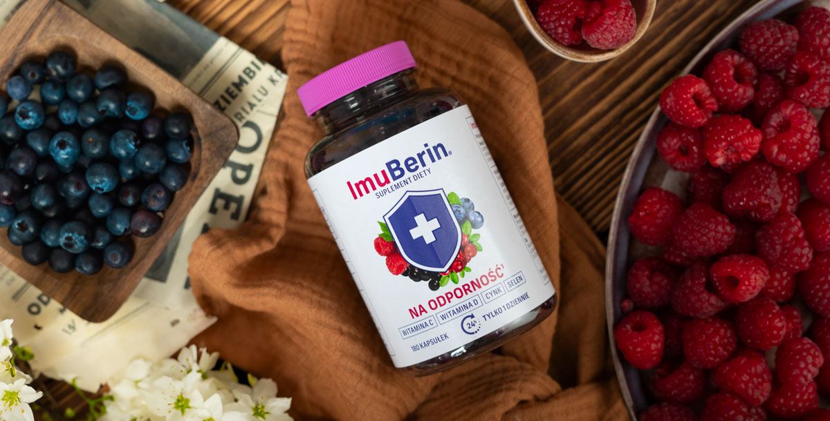 Natural Pharmaceuticals ImuBerin Toidulisand ImuBerin looduslike koostisosade hulgas – värsked vaarikad ja mustikad, pruuni kanga ja puidust laua taustal.